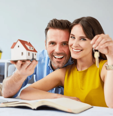 a man and woman holding keys to a house