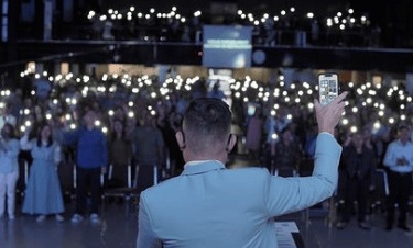 a man in a suit and tie is holding a glass of wine