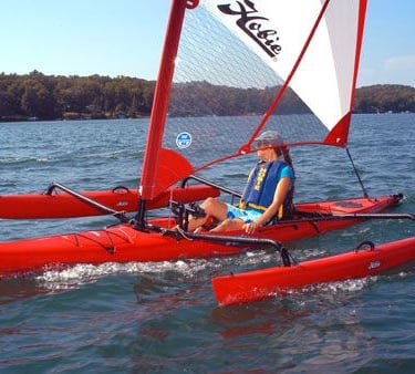 a man is sitting on a red kayak with sail