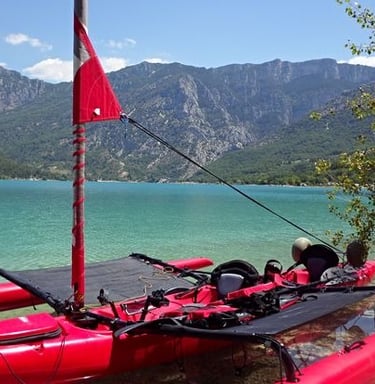 a red kayak is sitting on a rocky shore