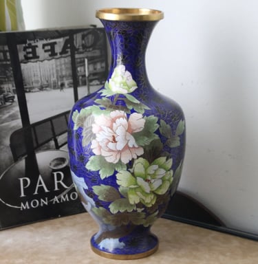 a blue vase with a flower on it