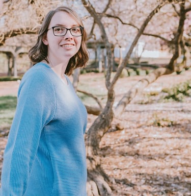 a woman in glasses and a blue sweater