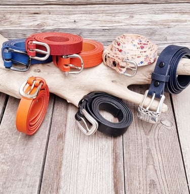 un tas de ceintures et de courroies sur une table en bois