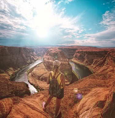 eine Person, die auf einer Klippe mit Blick auf einen Fluss steht