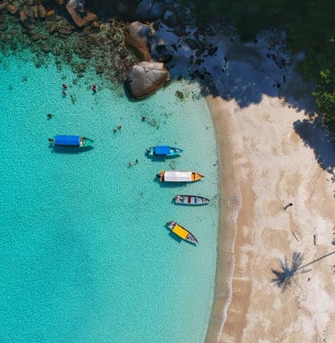 ein Strand mit Booten und Menschen auf und im Wasser