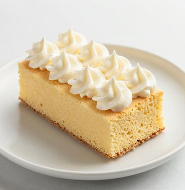 Close-up of a moist chocolate sponge cake with a delicate dusting of cocoa powder on a cream-colored plate.