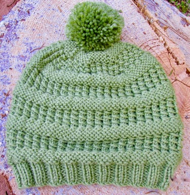 Green knitted hat with bamboo textured stitches and pompom