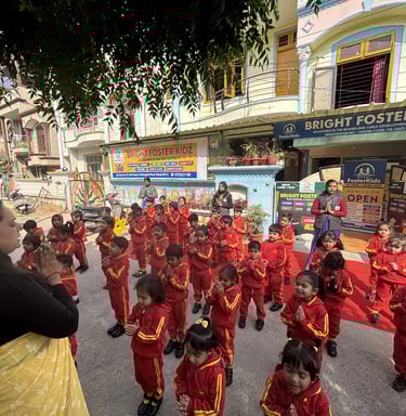 Students in red uniforms pray during morning assembly at Bright Foster Kidz preschool in India.