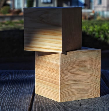 Two stacked cypress wood blocks showing natural grain texture on a rustic wooden table.