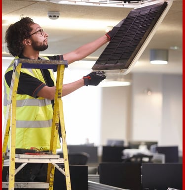Técnico realizando mantenimiento de aire acondicionado en oficina de Valencia