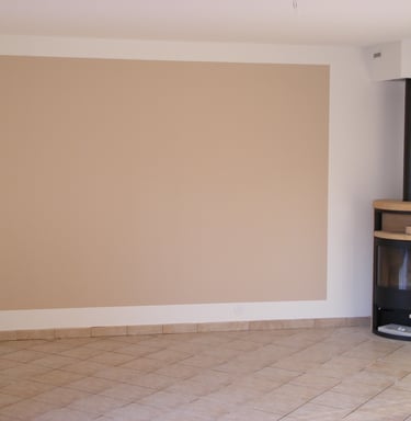 Peinture intérieure beige à côté d'un poêle, réalisée par Entreprise Couleurs Bassin