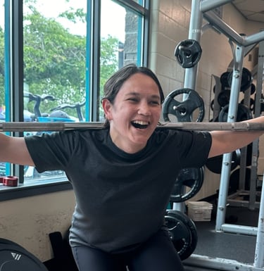 jessica kimball holding a squat bar and smiling