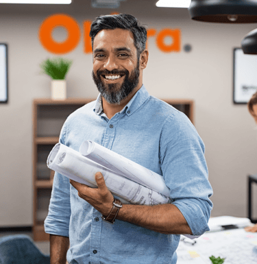 Homem sorridente segurando papéis, representando o setor administrativo da empresa.