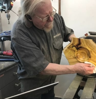 Woodturner Tom Baker at the lathe applying oil to Mulberry Crotch Natural Edge Winged Bowl