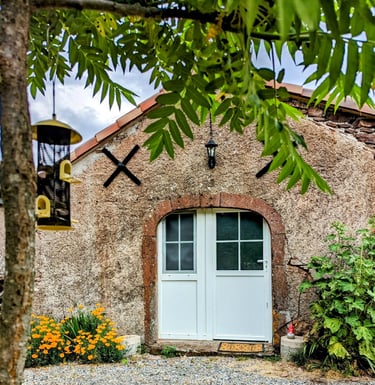 une mangeoire à oiseaux et la façade du Petit Logis