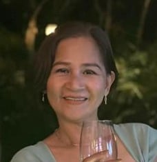 a woman in a green dress holding a wine glass