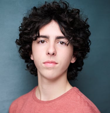 a man with curly hair and a red shirt headshot
