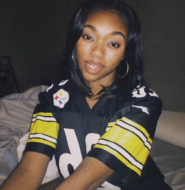 a woman in a football jersey is posing for a picture