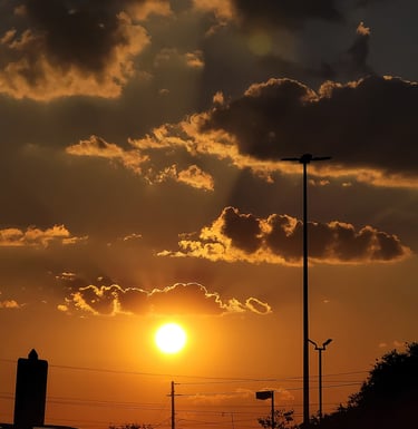 Yellow glowing sunrise with rays of sunlight shining through the clouds