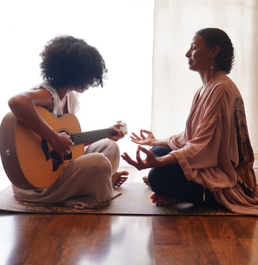 a woman sitting on a mat with a guitar and a guitar