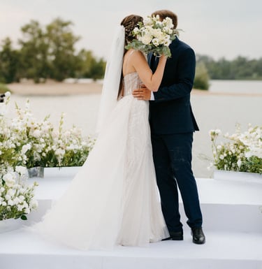 Bride and groom kiss at outdoor ceremony, bouquet raised—filmed by Imack Wedding Films, Glasgow.