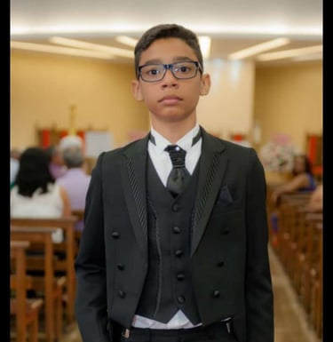 Foto de um garoto vestido com um terninho fino, de otima qualidade.