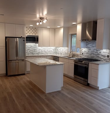 Modern kitchen remodel featuring white shaker cabinets, and stainless steel appliances.