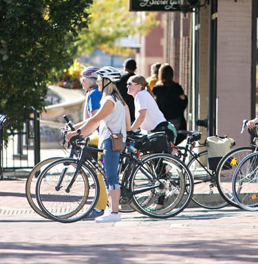 4 women on bikes stopped at a stop light