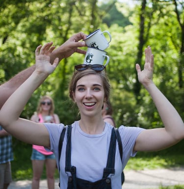 Woman balancing 2 Greenbelt stamped mugs on her head