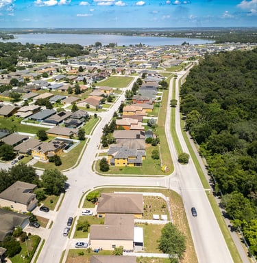 a city street with houses and trees in the background