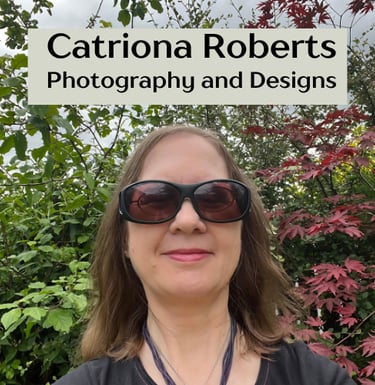 Image of a woman standing infront of shrubs.