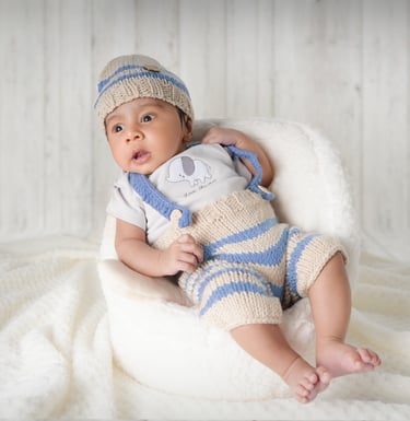 Newborn baby peacefully posed in a basket creating a dreamy and artistic portrait.