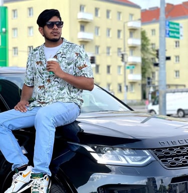 a man sitting on a car with a coffee cup
