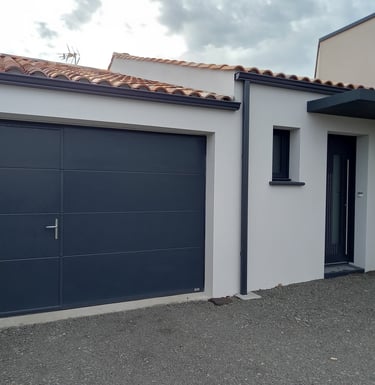 porte de garage noire avec porte intégrée et porte d'entrée mis par l'artisan menuisier en Vendée