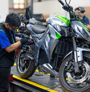 a man working on a motorcycle in a factory