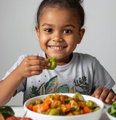 Smiling young child holding a green bell pepper slice, seated at a table with healthy fresh vegetables and a bowl of roasted