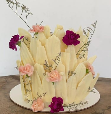 Bolo decorado com detalhes florais e texturas que imitam pétalas, ideal para festas e celebrações. D