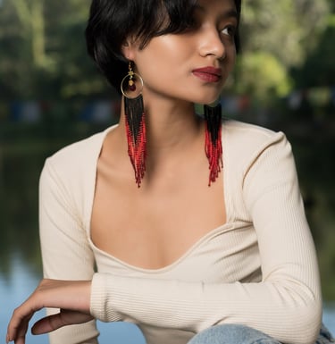 a woman with a long black hair and earrings