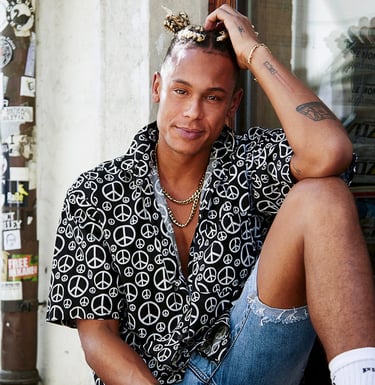a man sitting on a ledge with a peace sign