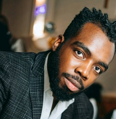 a man in a suit and tie is looking at the camera