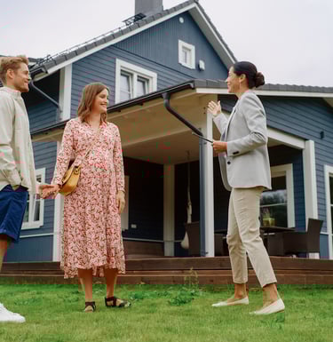 a man and woman standing in front of a house