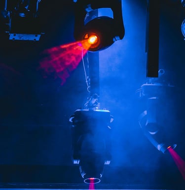 Professional stage lighting equipment projecting vibrant red laser beams through blue concert fog.