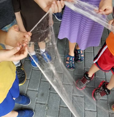 Closeup of children's hands pulling roving while attending the RIngling event.