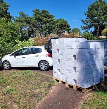 Voiture de livraison stationnée à côté d'une palette de Champagne La Bulle du Bassin
