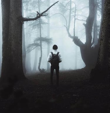 a man standing in a dark forest with a backpack