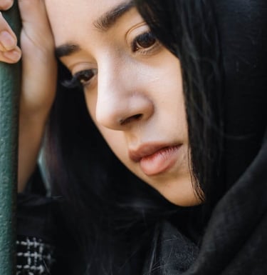 a woman in a black and white scarf in deep thoughts