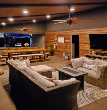 Outdoor living room and kitchen with cabin style walls and ceiling.