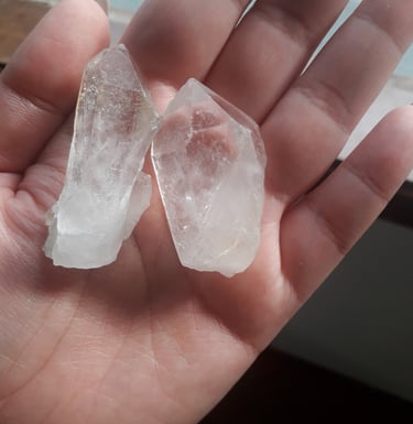 uma pessoa segurando dois pedaços de pedras transparentes