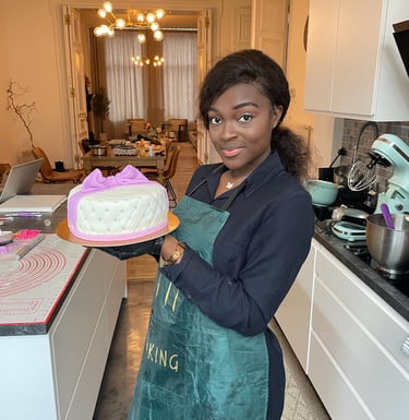 a woman in a green apron holding a cake