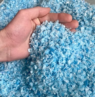 Gros plan sur du broyât de plastique PEHD recyclé bleu